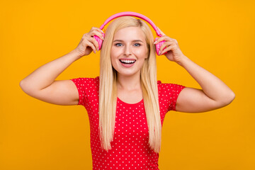 Photo portrait woman amazed listening music in headphones isolated vivid orange color background