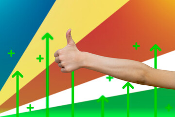 Seychelles flag with green up arrows, increasing values and improving economy,  finger thumbs up 