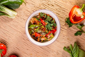 Bowl of stir-fried vegetables with peppers, onions, and tomatoes