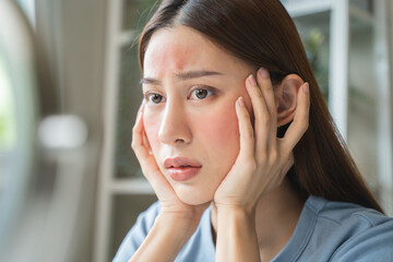 Sensitive skin with cosmetology, Asian young woman looking at red spot on her face from cosmetic...