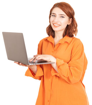 Using laptop, image of young red bob hair caucasian 20s woman holding using laptop. Smiling looking to camera. Standing over light pink background. Isolated portrait, copy space. Technology concept.