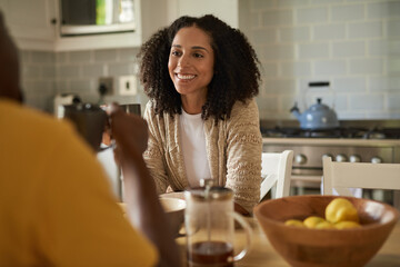 Smiling African woman drinking coffee and talking with her husband at breakfast - Powered by Adobe
