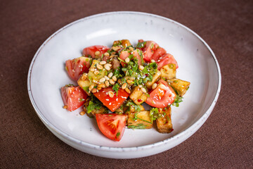 warm eggplant and tomato salad with nuts in the cafe
