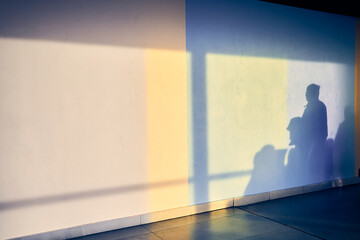 Abstract background of a man's shadow on a white wall at the airport with space to copy. Blurred silhouettes of people. High quality photo