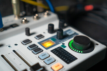 Close-up image of hand adjusting mixer knob for volume control during live studio performance....