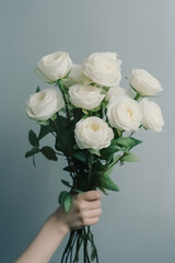 Person holding bouquet of white roses