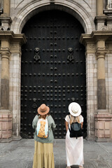 tourists with their backs in front of an ancient door. - obrazy, fototapety, plakaty