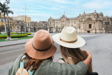 Women looking at government palace in Peru.