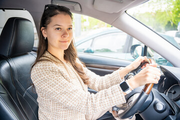 Side portrait of young caucasian woman driving car in the city