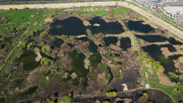 High angle drone shot of Vacaresti Nature Park in Bucharest. Natural reserve in the middle of the capital city of Romania. Swamp, bird's nests and paths for hiking and nature exploration.
