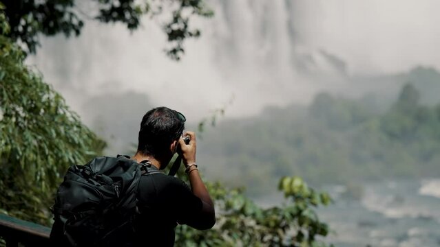 Male Tourist Taking Photos And Videos At Iguazu Falls In Argentina - Medium Shot