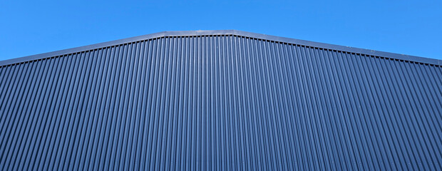 Minimalist blue building roofline and clear blue sky