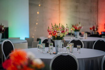 Dobele, Latvia - August 18, 2023 - A flower arrangement on an event table with candles, glasses,...