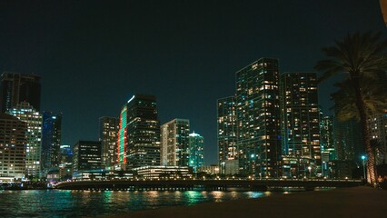 Obraz premium the beach and buildings of downtown at night time, and with the sea as background