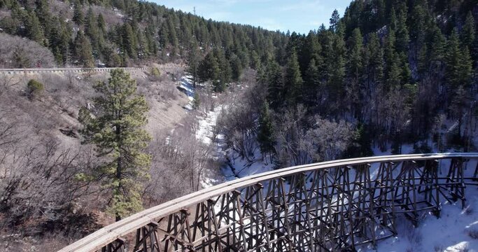 Drone shot flying back revealing a historic narrow gauge truss railway in the New Mexico Mountains near Cloudcroft