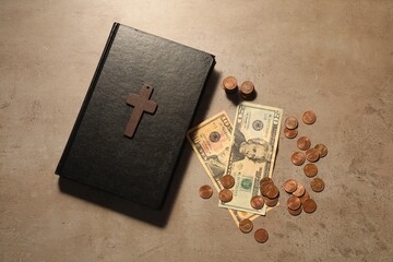 Donate and give concept. Coins, Bible, cross and dollar banknotes on grey table, flat lay