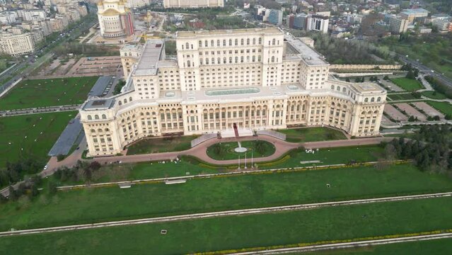 Aerial drone footage of the People's Palace in Bucharest Romania. Romanian Parliament seen from above on a green spring day. Brutalist architecture landmark of post-communist Europe.
