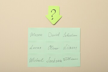 Choosing baby`s name. Paper stickers with different names and question mark on beige background, flat lay