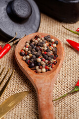 colher da pau sobre a mesa com pimenta do reino foto na vertical no detalhe 