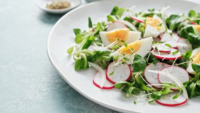 Spring radish and eggs salad. Fresh Easter salad with boiled eggs, cornsalad lettuce and radish. Stock footage video 4k