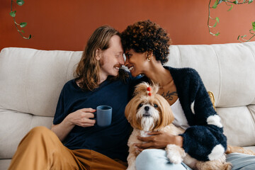 Couple enjoying a cozy moment with their dog on the couch