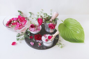 Spa still life with rose petals, salt and flowers on a white background