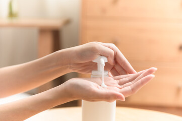 Close up woman hand pressing body lotion moisturizer cream from bottle. Woman body beauty cosmetic skin care concept.
