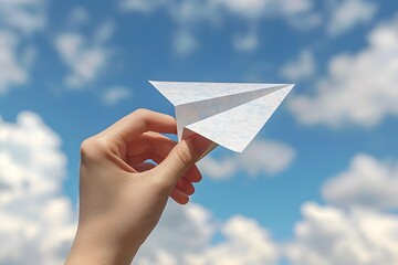 Hand Holding Paper Airplane Against Blue Sky with Fluffy Clouds