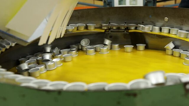 Metallic round caps in vibratory bowl feeder spin in large drum for sorting