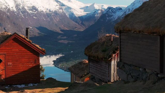 Drone reveal Norway glacier and valley in sunset from old mountainside cabins