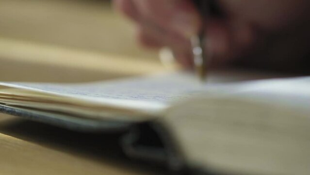 Closeup long static shot, writing hands place ballpoint pen in sketch notebook