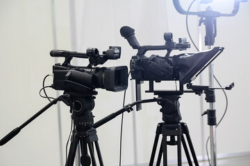 Video cameras on tripods and studio lights pavilion. Industry
