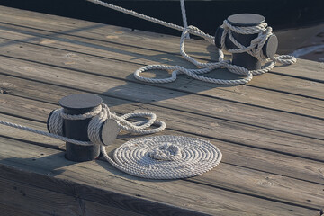 Mooring rope with a knotted on a wooden pier. Nautical mooring rope