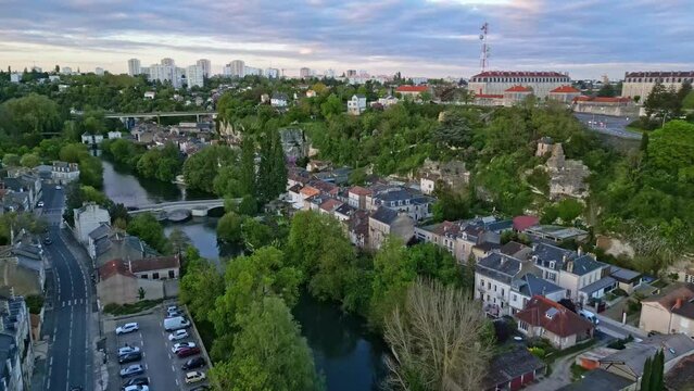 Clain river crossing Poitiers city, France. Aerial forward at sunset