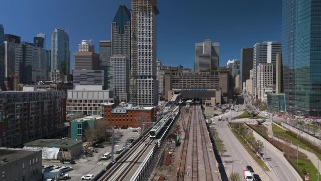 Aerial of REM automated light rail system subway train entering Montreal city with skyline building in Quebec capital , Canada 