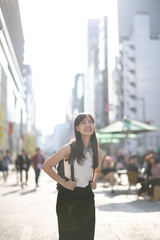 Modern fashion in Tokyo, a stylish Asian woman walking in the vibrant city, radiating happiness and confidence.