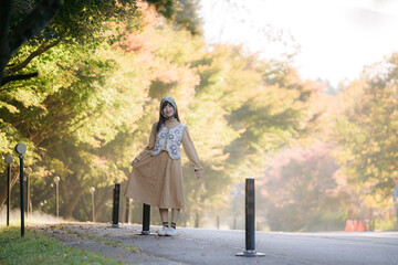 Casual dress elegance, Asian woman enjoys fall in Japan. Kyoto portrait with colorful maple...