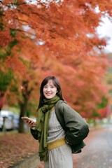 Asian woman in a stylish sweater, enjoying the fall season. A pretty and cheerful portrait capturing the essence of nature.