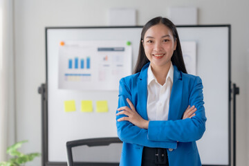 Portrait of Asian businesswoman in the office. Crossed arms. Confident Asian Businesswoman Standing...