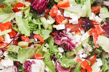 Greek salad background. Various ingredients lunch meal. Healthy vegetable snack. White feta cheese and honey vinegrette dressing. Crunchy lettuce and bell pepper. Raw vegetables.