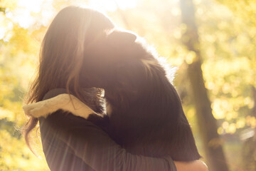 cute border collie dog hugging a young woman in a forest