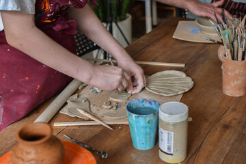 girl working with clay on the table in a pottery