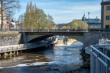 Motala Stream and bridge Järnbron in the industrial landscape of Norrköping during spring in Sweden. The first notion of a bridge at this location dates back to 1330.