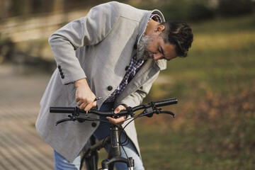 Man Fixing the Handlebars of His Bicycle Before Riding