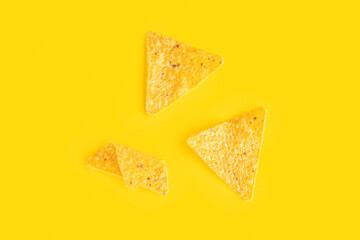 Corn chips nachos on yellow background.