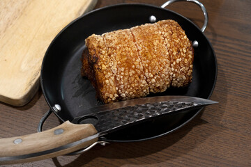 Crispy pork chashu in a pan on a wooden table