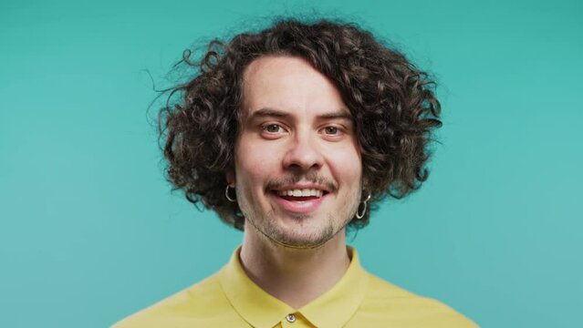 Friendly man showing yes signal, nods head, approve. Positive smiling curly guy