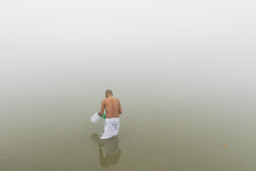 03 Jan 2024, Sultanganj, Bihar, Devotees wearing saffron clothes taking holy dip bathng in Ganga river