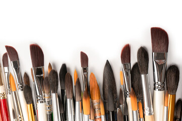Mix of paint brushes in a row isolated on a white background.  Top view.