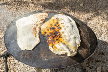 Cooking flatbread or Pita bread on outdoor. Preparing Druze Pita..